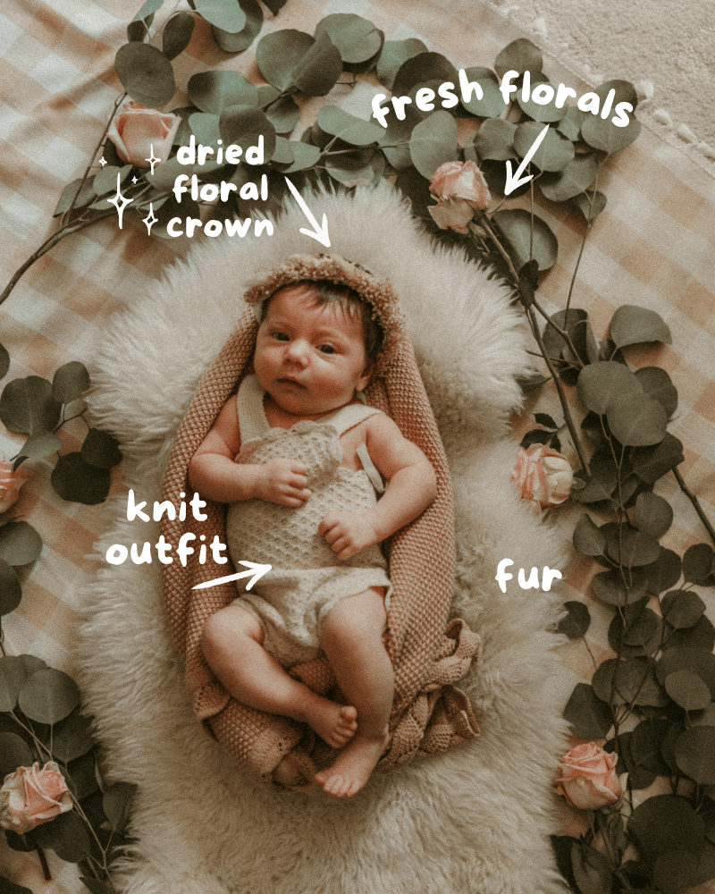 Overhead image of a sleeping newborn baby girl wrapped in a textured pink swaddle and placed in a Moses basket lined with faux fur. The setup includes a neutral gingham tablecloth, a large bow headband, and labeled prop elements for newborn photography, offering a behind-the-scenes look at a cozy, styled setup.