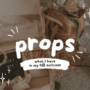 Flat lay of open suitcase filled with newborn photography props and a leather bag