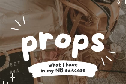 Flat lay of open suitcase filled with newborn photography props and a leather bag