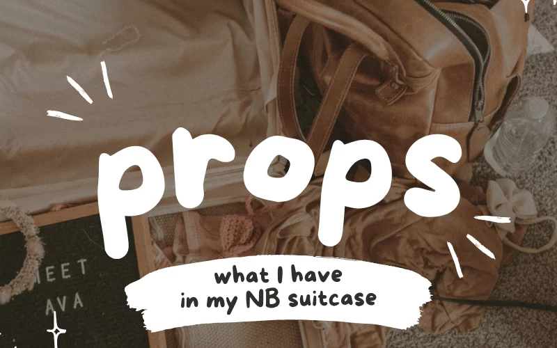 Flat lay of open suitcase filled with newborn photography props and a leather bag