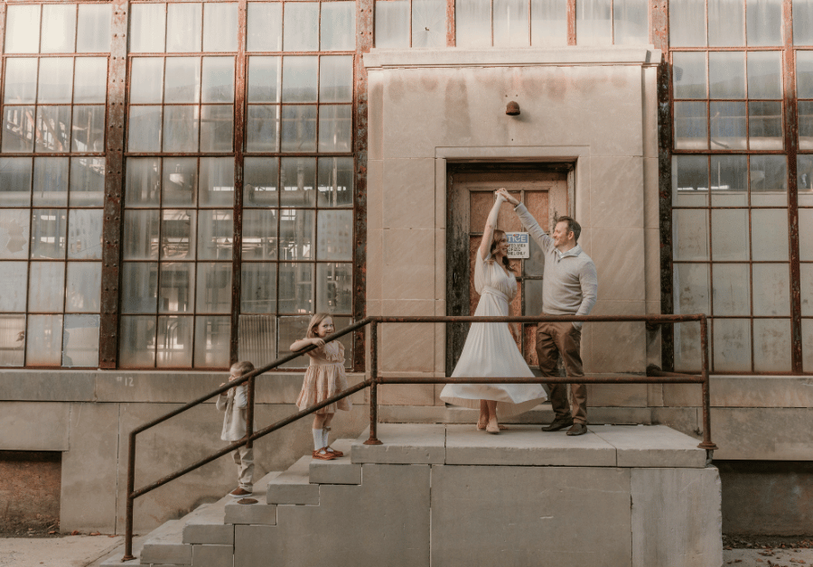 Family photo at industrial building with parents dancing and children watching